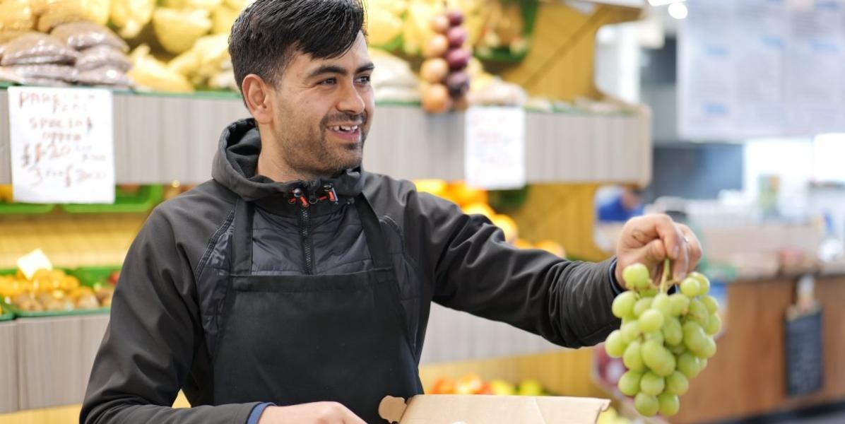 SuperVeg trader holding grapes