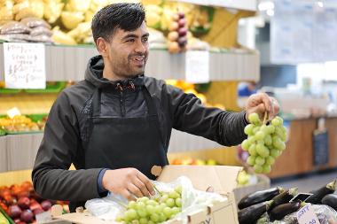 SuperVeg Trader holding grapes